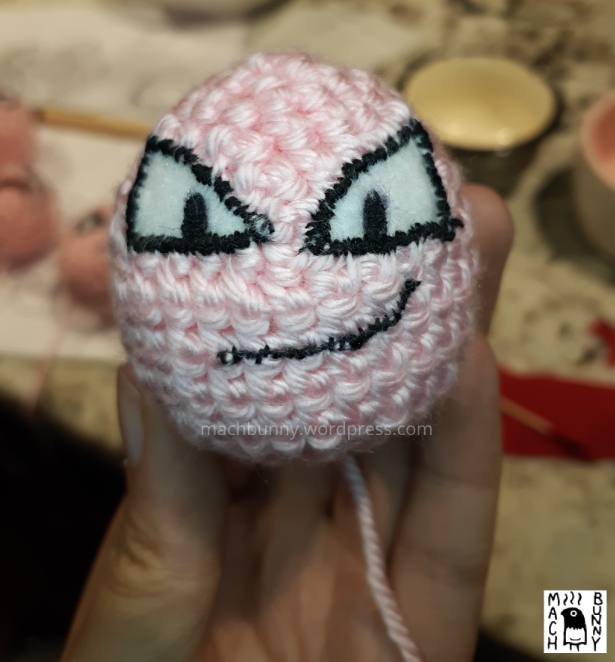 Amigurumi Exeggcute, front view of main egg with mouth being stitched into place